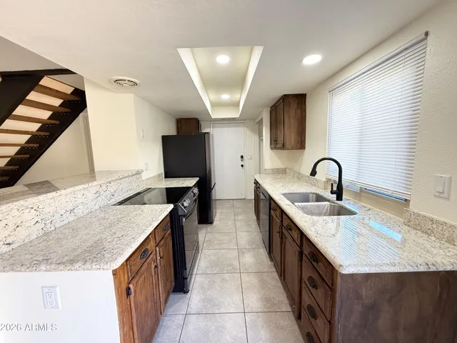 a kitchen with granite countertop a sink and a stove