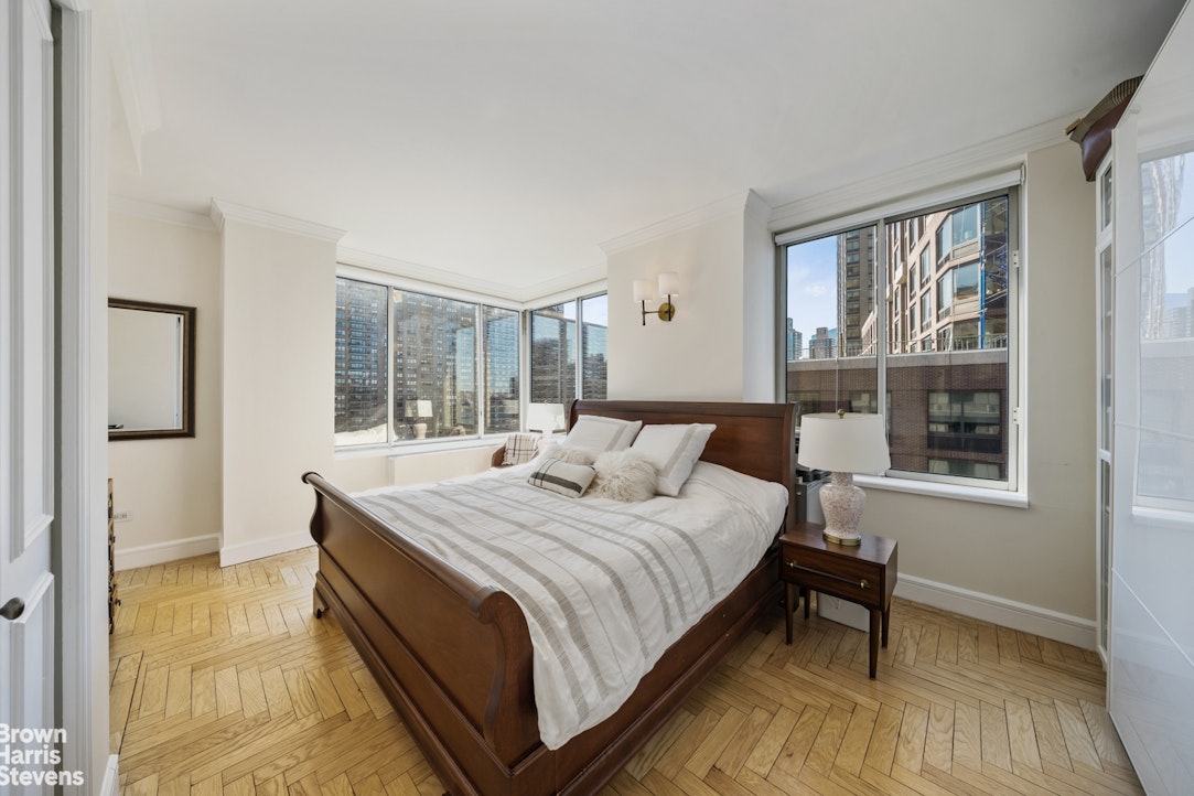 200 Riverside Boulevard, Unit 15I Manhattan, NY 10069 - Photo 11 of 23 a bedroom with a bed lamp and a large window