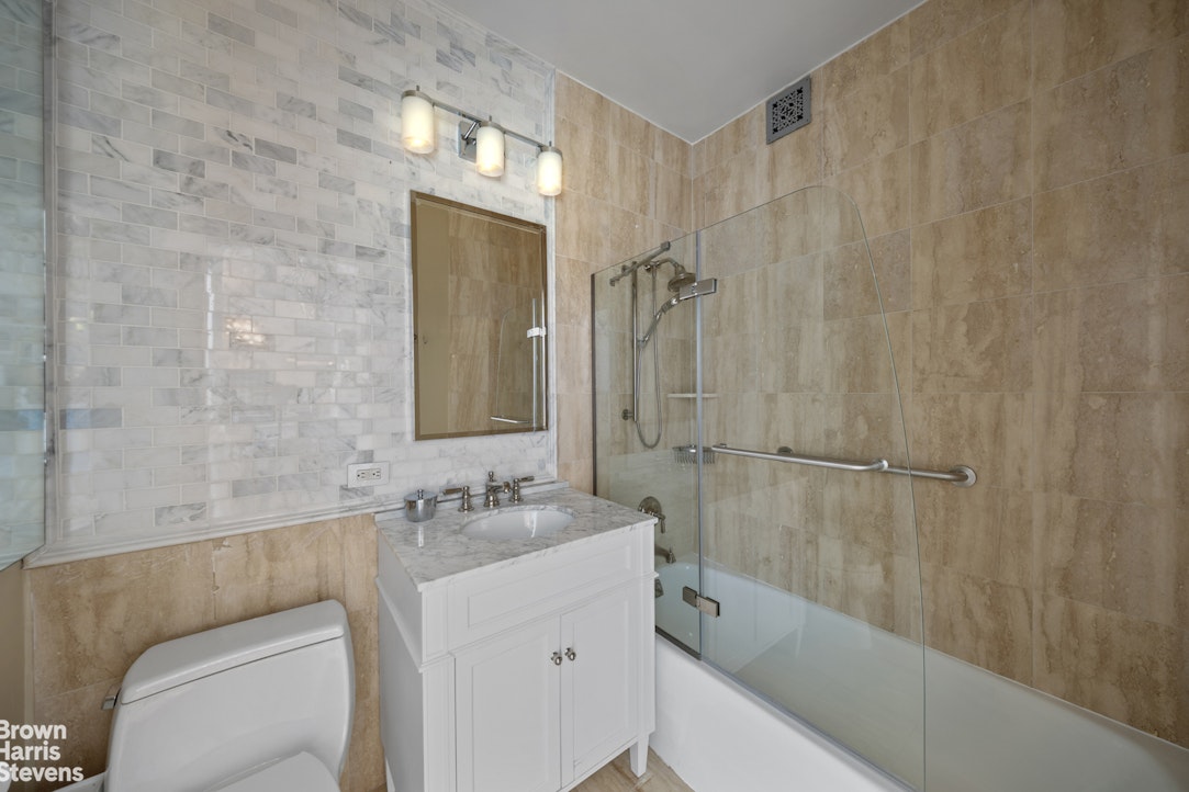 200 Riverside Boulevard, Unit 15I Manhattan, NY 10069 - Photo 19 of 23 a bathroom with a bathtub a sink a toilet and a shower