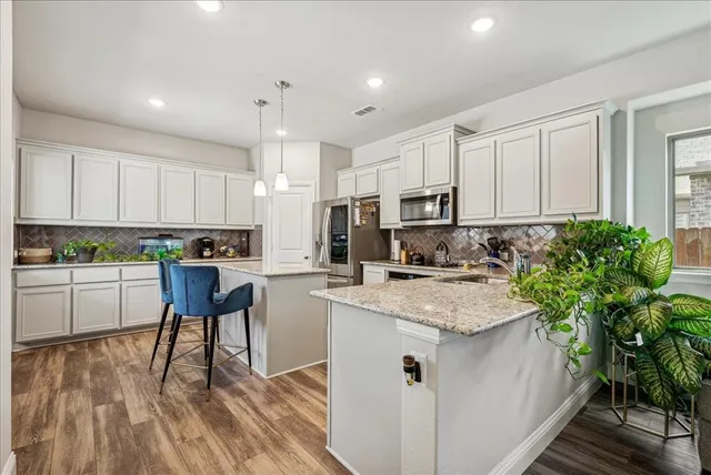a kitchen with white cabinets and appliances