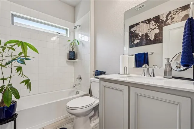 a bathroom with a granite countertop toilet sink and mirror