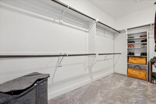 a view of walk in closet with empty racks