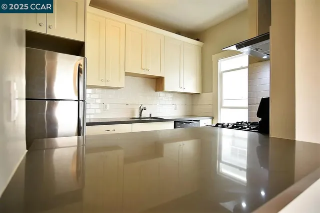 a kitchen with a refrigerator a stove a sink a microwave and cabinets