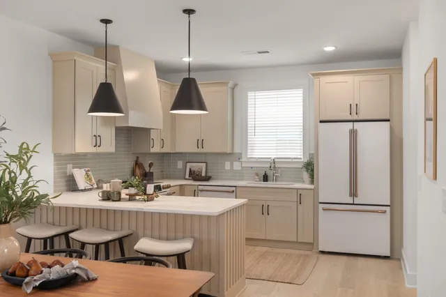 a kitchen with stainless steel appliances granite countertop a sink a stove a refrigerator and island with wooden floor