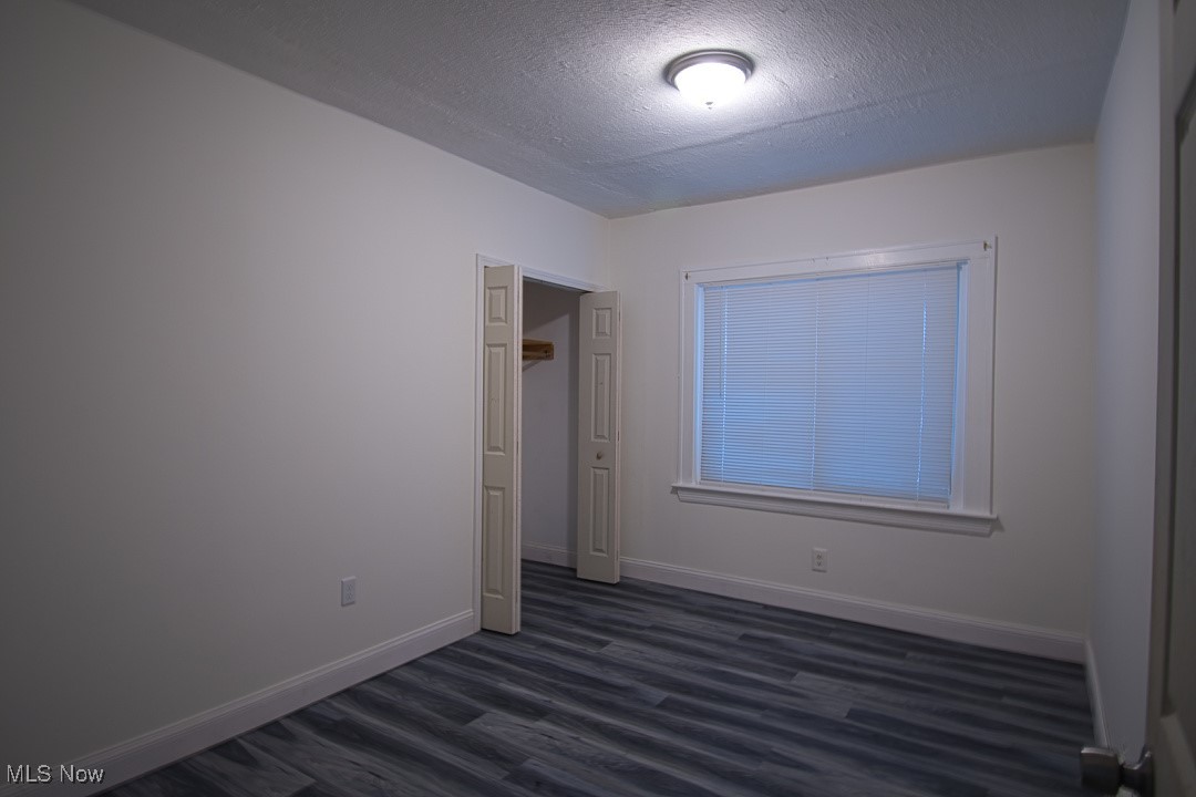 5402 Biddulph Road Cleveland, OH 44144 - Photo 9 of 20 Unfurnished bedroom with a textured ceiling and dark wood-type flooring