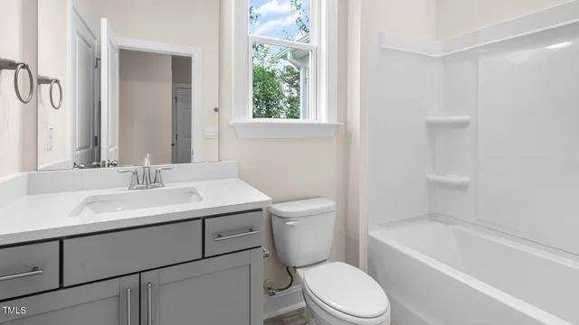a bathroom with a sink toilet vanity and bathtub