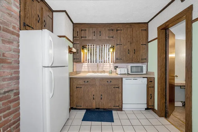 a kitchen with a refrigerator sink and cabinets