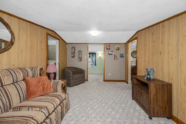 a living room with furniture a refrigerator and a large window