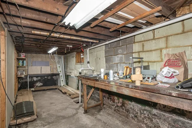 a room with stainless steel appliances kitchen island granite countertop lots of clutter