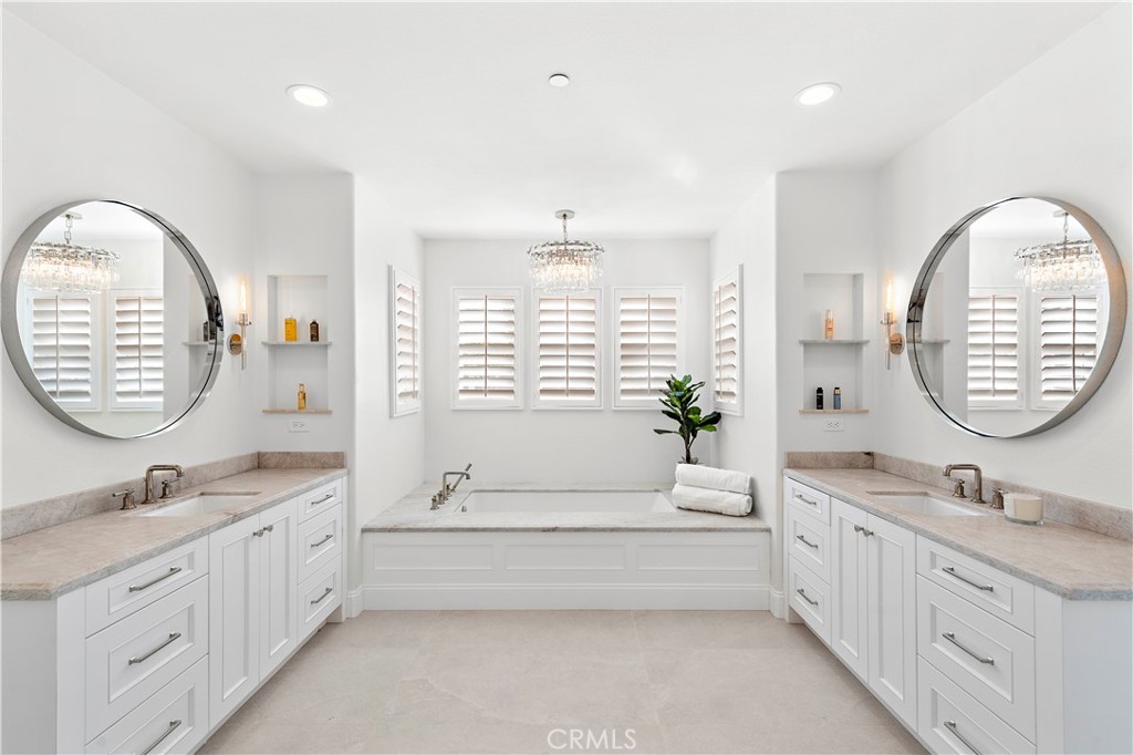 8 Kane Lane Ladera Ranch, CA 92694 - Photo 19 of 49 a spacious bathroom with a double vanity sink a large mirror and a bathtub next to a window