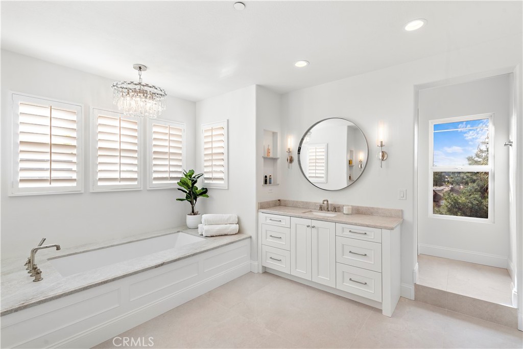 8 Kane Lane Ladera Ranch, CA 92694 - Photo 20 of 49 a bathroom with a granite countertop sink a mirror a window and a bathtub