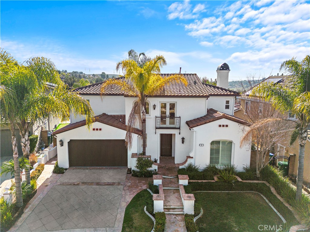 8 Kane Lane Ladera Ranch, CA 92694 - Photo 2 of 49 a view of a white house with a yard and table and chairs under an umbrella