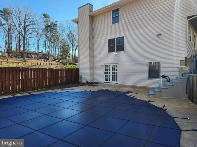 a view of backyard with barbeque grill and wooden fence