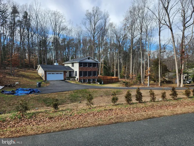 a view of a house with trees and sitting area