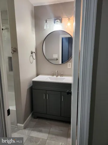 a bathroom with a sink vanity and a mirror