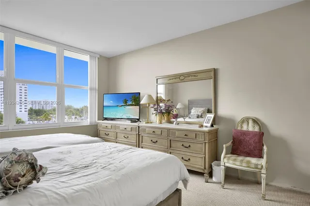 a bedroom with a bed and large windows