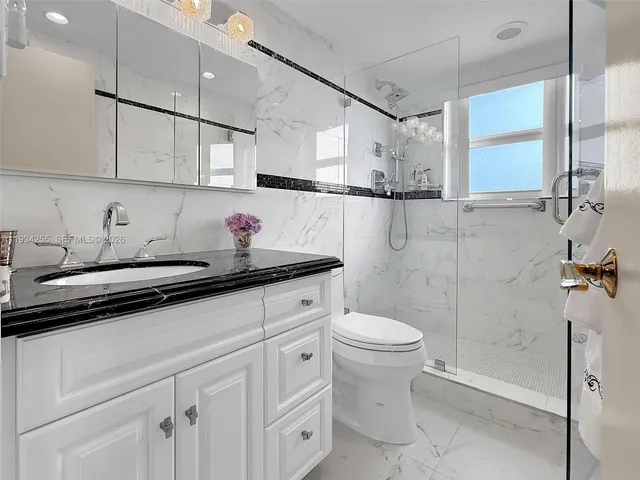 a bathroom with a sink a toilet and shower