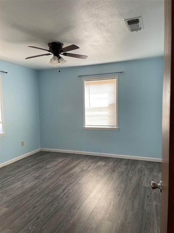 2506 Vincent Street Brownwood, TX 76801 - Photo 16 of 40 a view of an empty room with wooden floor and a window