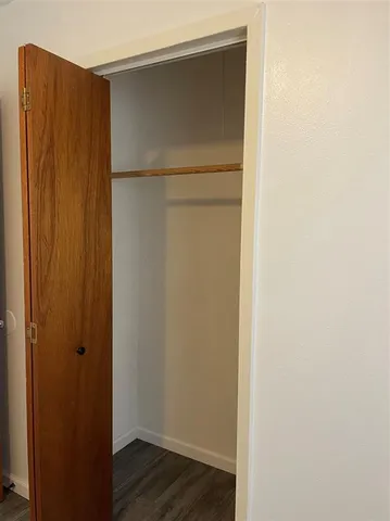 a view of walk in closet with wooden floor