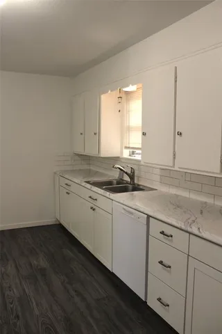 a room with a sink cabinets and a window