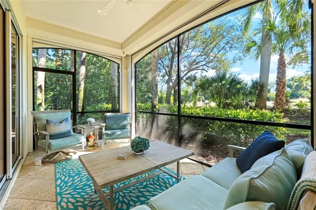 a living room with patio furniture and a floor to ceiling window
