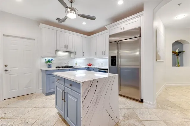 a kitchen with stainless steel appliances granite countertop a refrigerator a stove and a sink