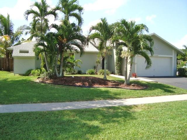 11460 Woodchuck Drive Boca Raton, FL 33428 - Photo 1 of 32 a front view of a house with garden