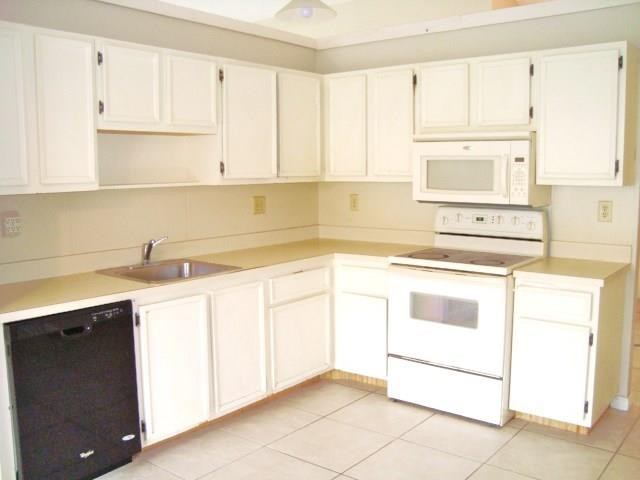 11460 Woodchuck Drive Boca Raton, FL 33428 - Photo 11 of 32 a kitchen with granite countertop white cabinets and white appliances