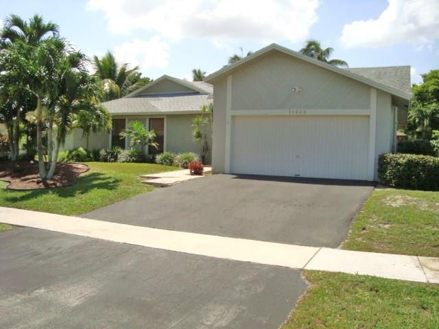 11460 Woodchuck Drive Boca Raton, FL 33428 - Photo 3 of 32 a backyard of a house with yard and outdoor seating
