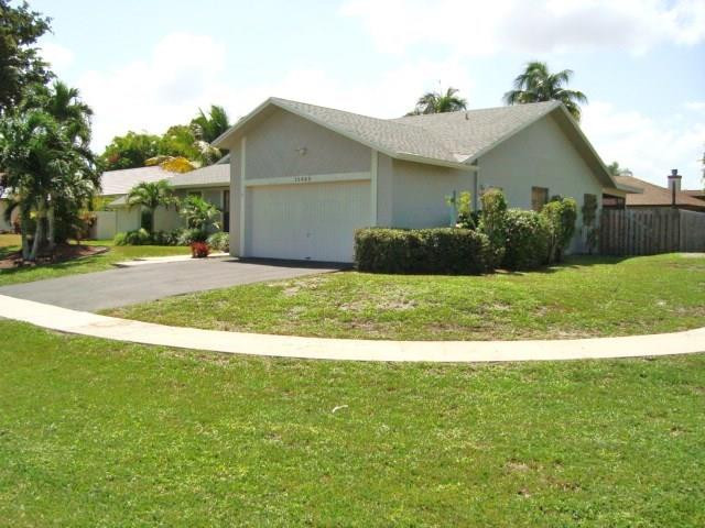 11460 Woodchuck Drive Boca Raton, FL 33428 - Photo 5 of 32 a view of a house with a yard and garage