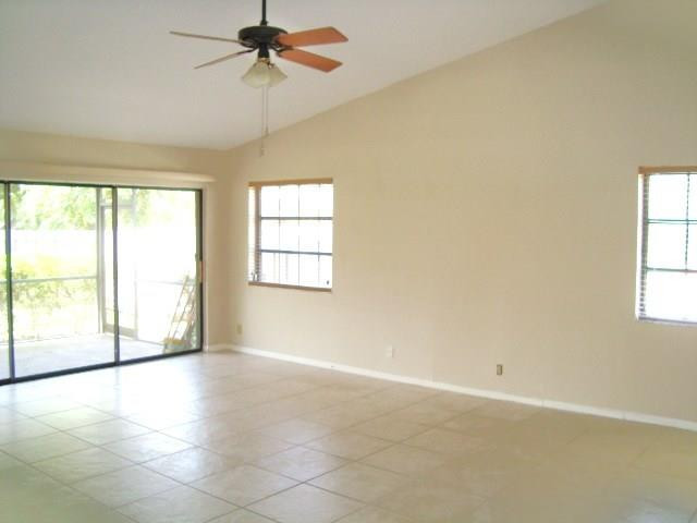 11460 Woodchuck Drive Boca Raton, FL 33428 - Photo 6 of 32 an empty room with chandelier fan and windows