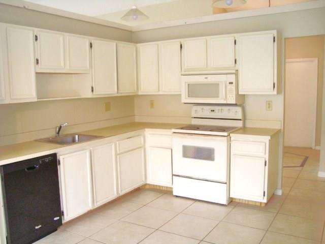 11460 Woodchuck Drive Boca Raton, FL 33428 - Photo 10 of 32 a kitchen with white cabinets stainless steel appliances and sink