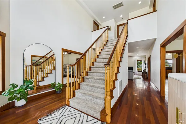 a large living room with stainless steel appliances granite countertop wooden floors and a large window