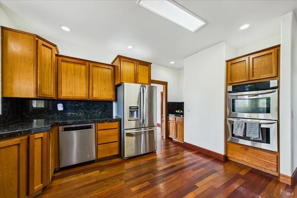 a view of a livingroom with a chandelier fan and windows