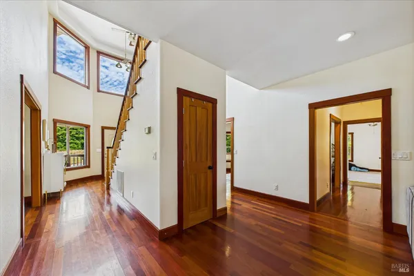 a view of a hallway with wooden floor and staircase