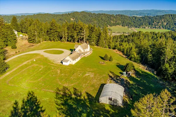 a view of a house with a small yard and wooden floor and fence