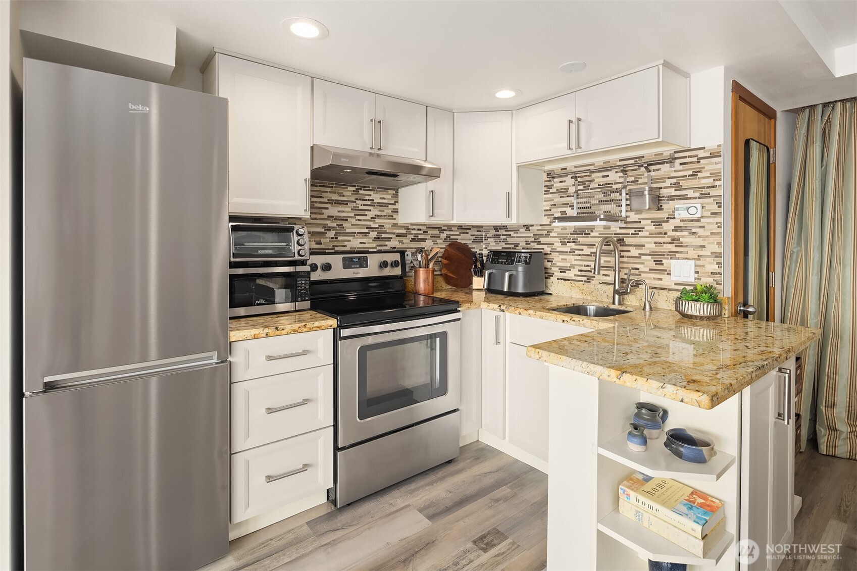 16947 Maplewild Avenue Southwest Burien, WA 98166 - Photo 14 of 23 a kitchen with stainless steel appliances granite countertop a stove a refrigerator and a sink