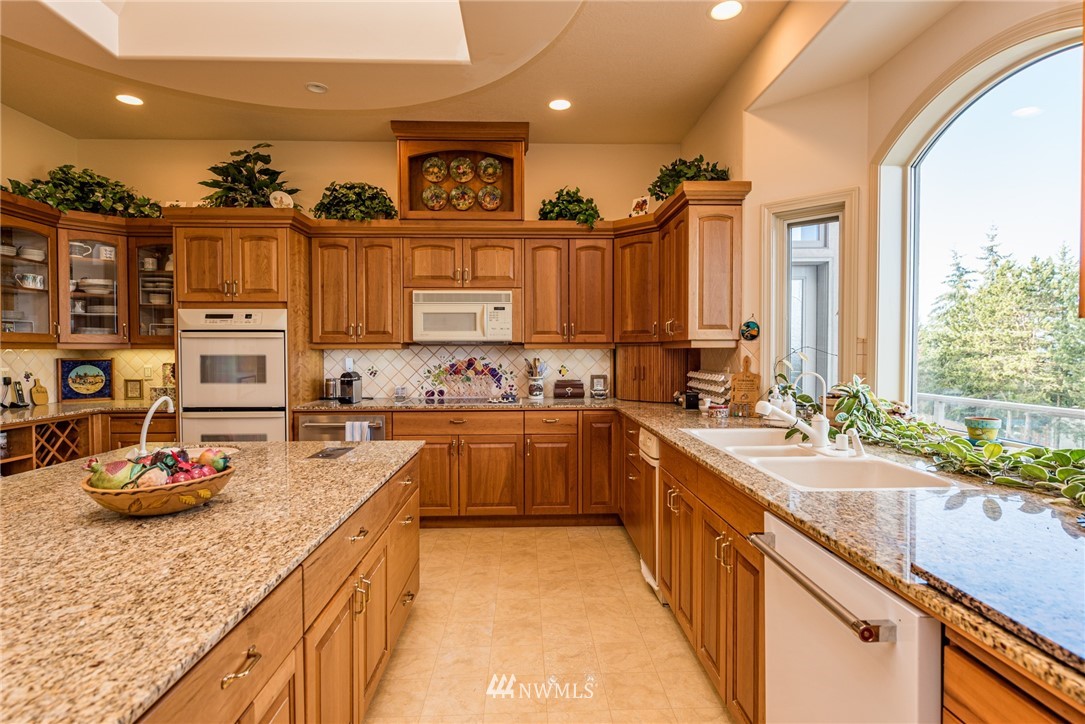 53 Quails Roost Road Sequim, WA 98382 - Photo 16 of 40 a kitchen with kitchen island granite countertop a sink appliances and cabinets