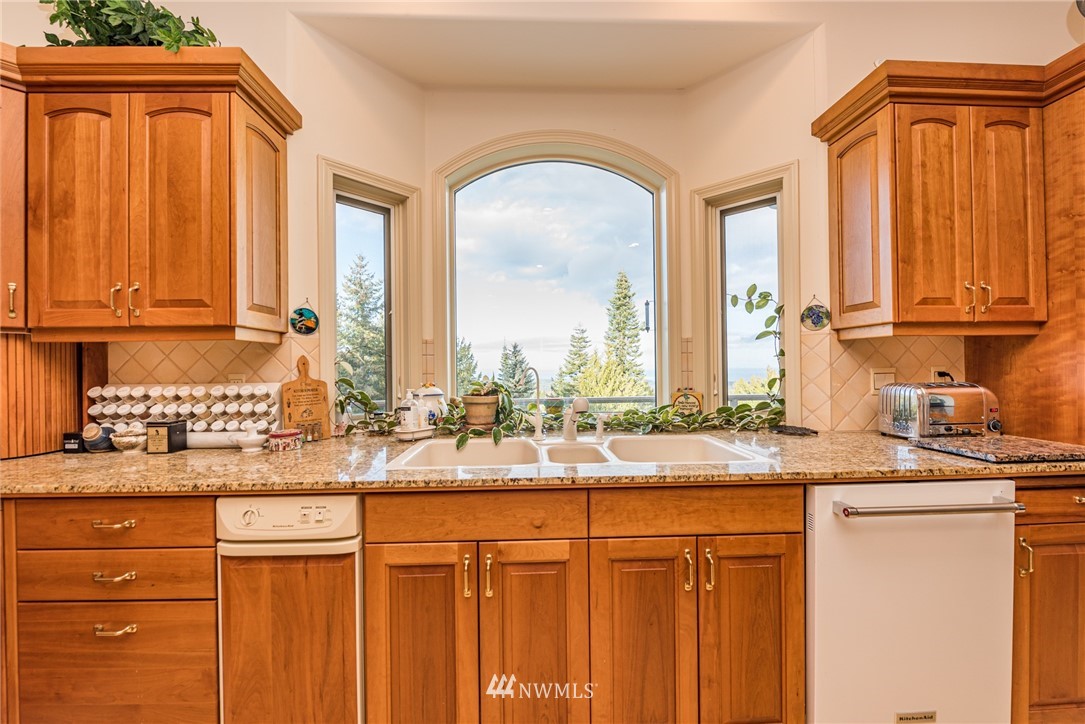 53 Quails Roost Road Sequim, WA 98382 - Photo 17 of 40 a kitchen with stainless steel appliances granite countertop a sink and cabinets with wooden floor