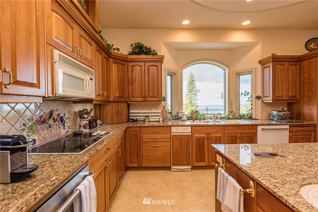 53 Quails Roost Road Sequim, WA 98382 - Photo 18 of 40 a kitchen with stainless steel appliances granite countertop a sink a stove and cabinets