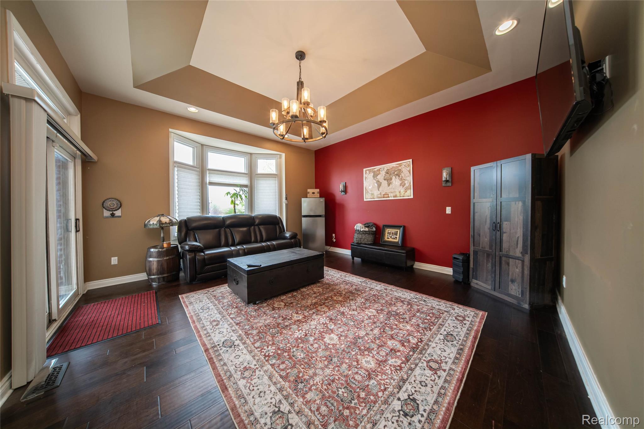 67102 Rachael Lane Washington, MI 48095 - Photo 18 of 37 Living room with a tray ceiling, a chandelier, and dark wood-style flooring