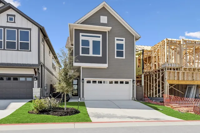 a view of a house with a yard and potted plants