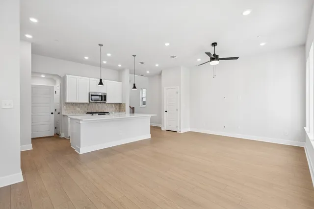a view of kitchen with kitchen island white cabinets and stainless steel appliances