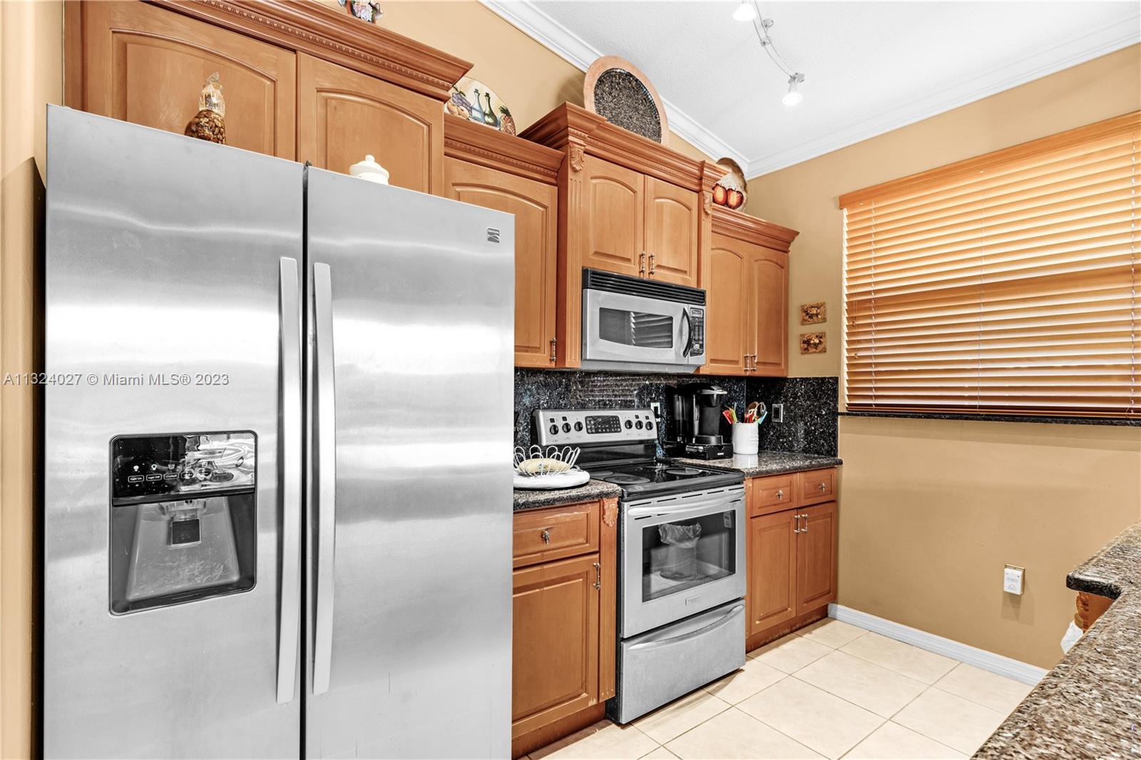 16056 Southwest 66th Terrace Miami, FL 33193 - Photo 9 of 24 a kitchen with stainless steel appliances granite countertop a refrigerator a stove and a sink