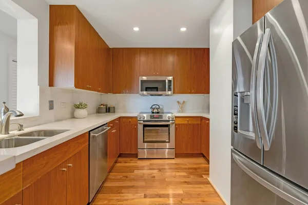 a kitchen with stainless steel appliances granite countertop a refrigerator sink and stove