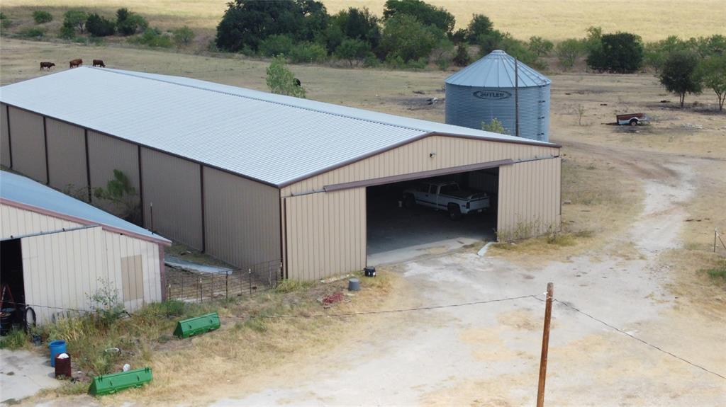 410 State School Road Gatesville, TX 76528 - Photo 24 of 39 Metal-sided barn structure with a light-colored roof, featuring a large open bay