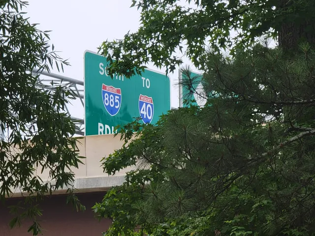 a sign that is sitting in front of a tree