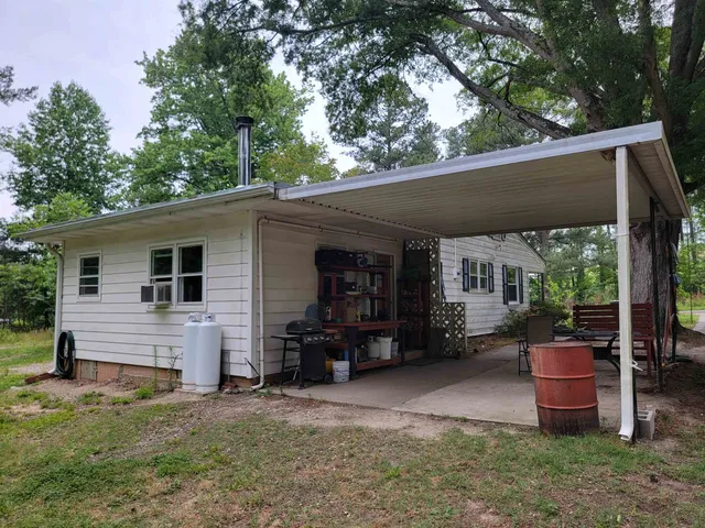 a view of a house with a backyard and chairs
