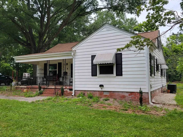 a view of a house with a yard and sitting area