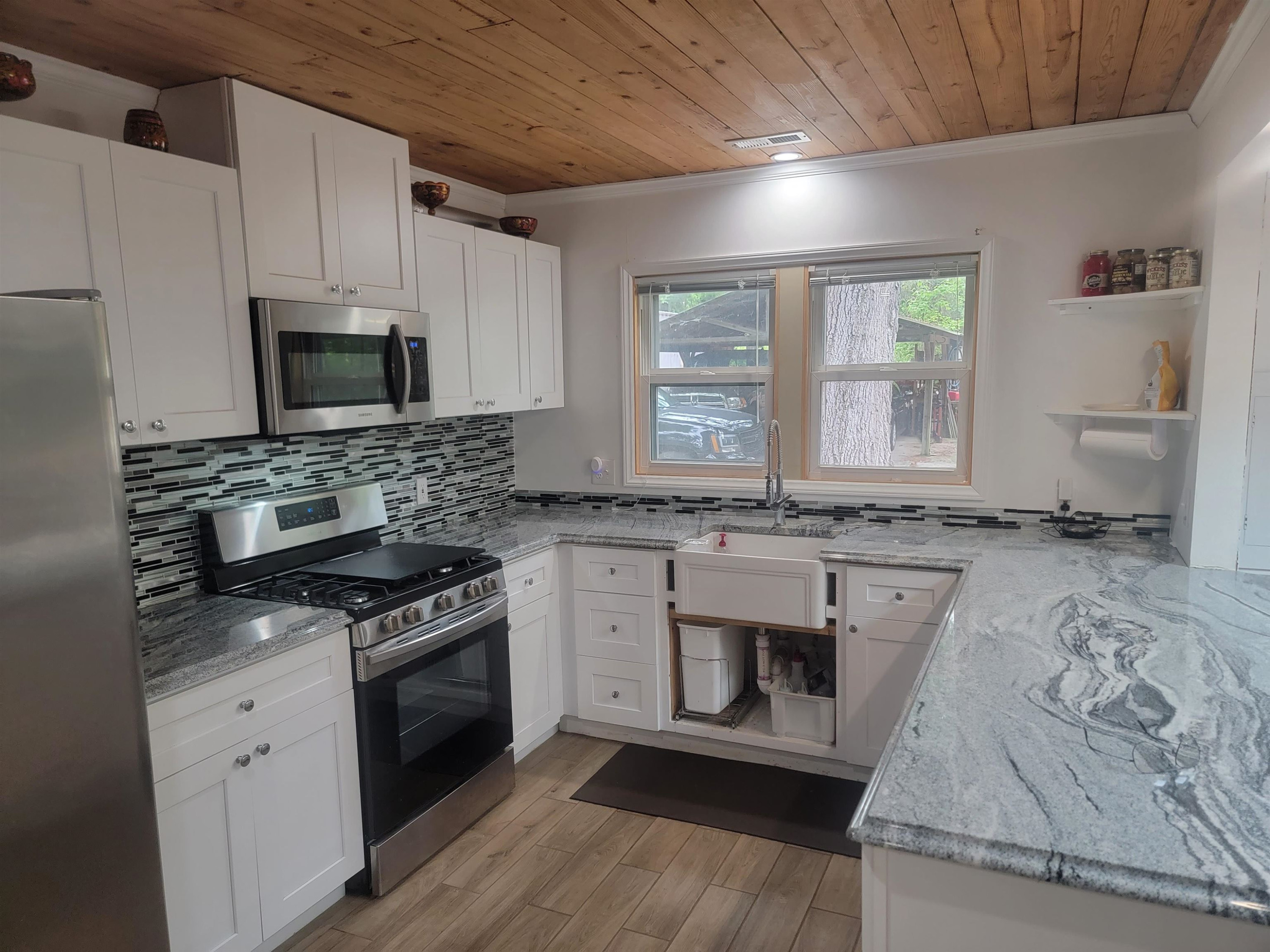3217 Rowena Avenue Durham, NC 27703 - Photo 24 of 30 a kitchen with stainless steel appliances granite countertop a stove a sink and a microwave